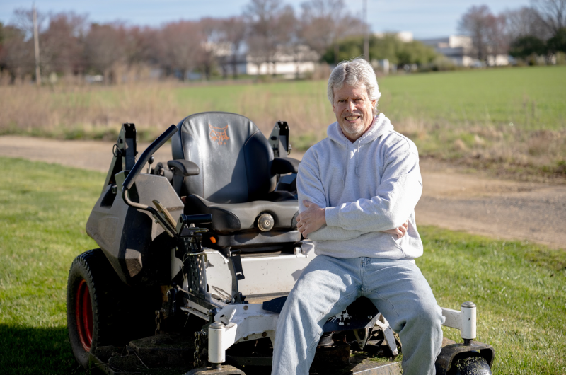 58-year-old Matawan, New Jersey, man sits on his riding lawnmower.