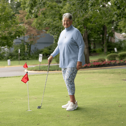 Kathryn Moore, 80, of Manchester, New Jersey, holds her golf club while standing on a putting green.