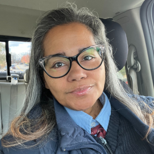 Ruth Rodriguez sits in a vehicle and smiles at the camera.