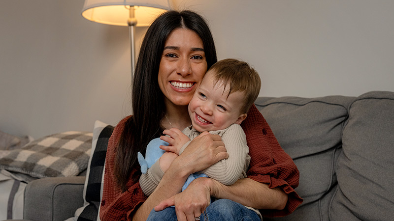 Image shows Hackensack Meridian Health Patient, Amanda Lee Davis, posing for a photo with her young son on the couch.