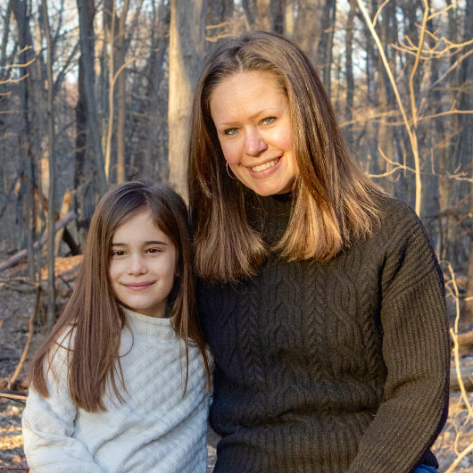 Standing with trees behind her, Dawn Congiusti smiles at the camera.