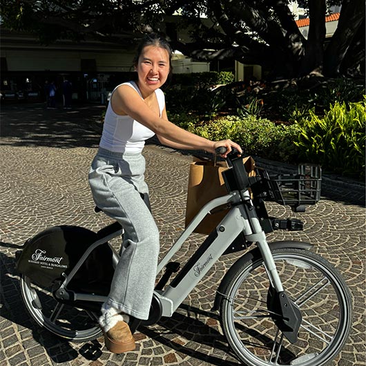 Tram Huynh of San Jose, California smiles while riding an e-bike.