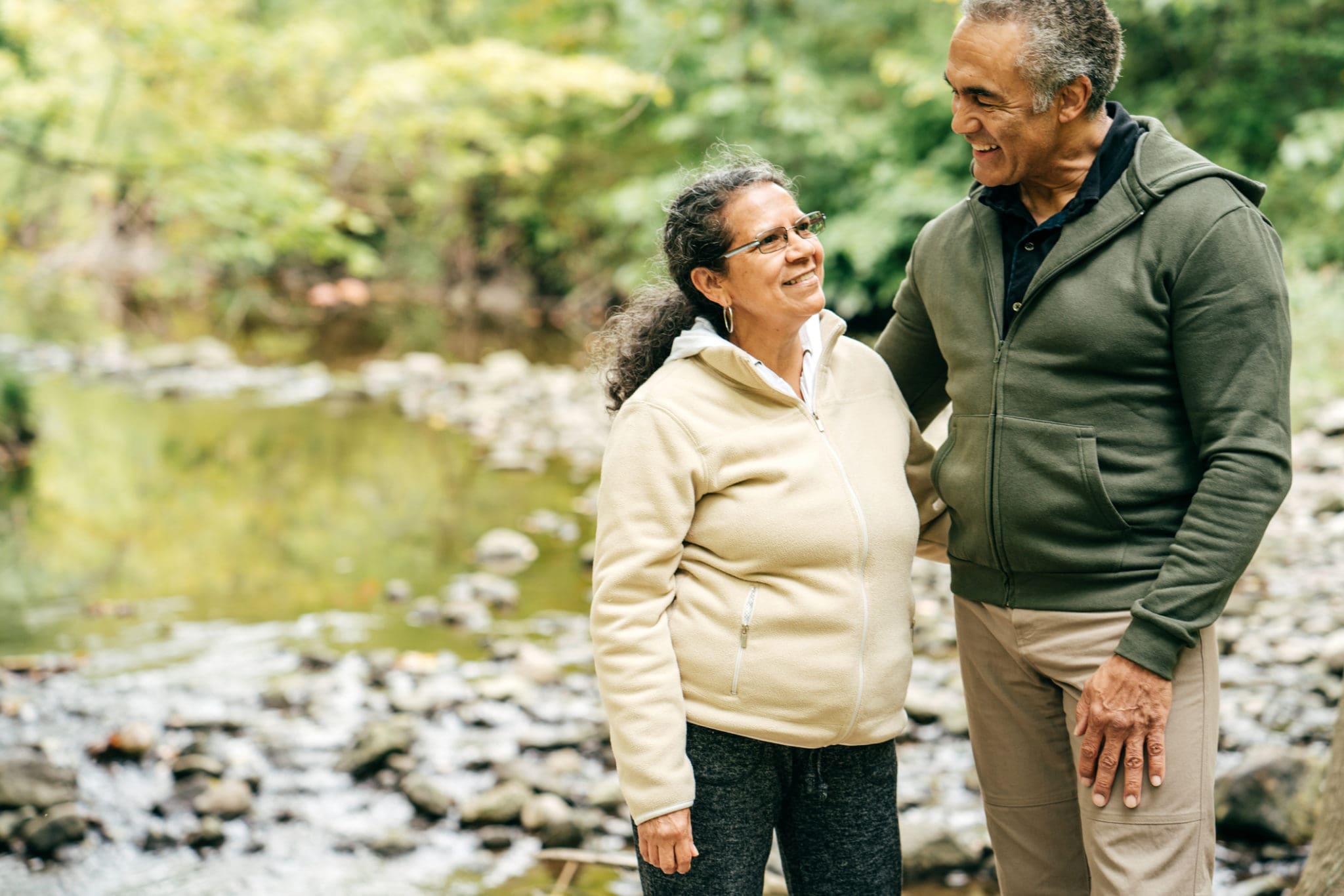 Man and woman smiling beside river