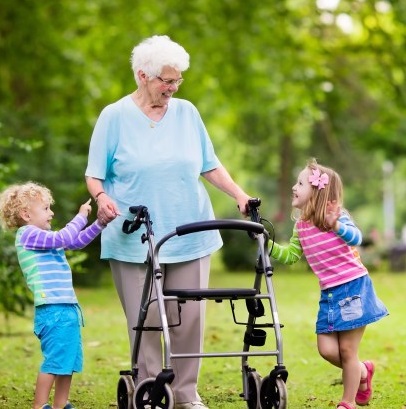 older woman using walker and young kids on either side