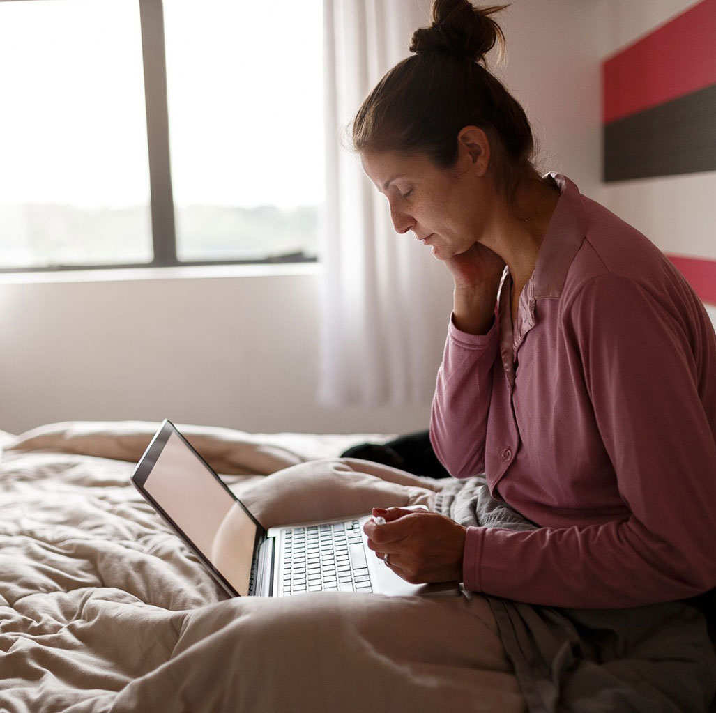 Woman in Bed at Telemedicine Appointment