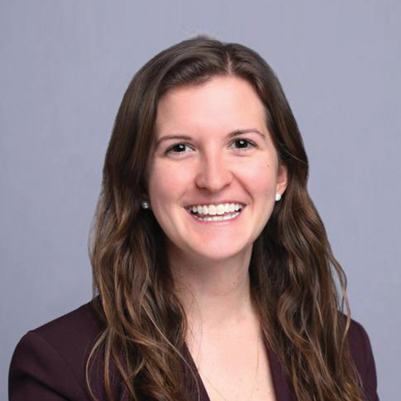 women with long brown hair smiling wearing a black blazer