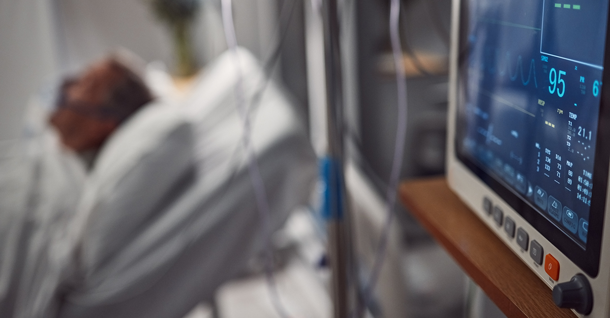 Faded image showing patient in hospital bed and monitoring device