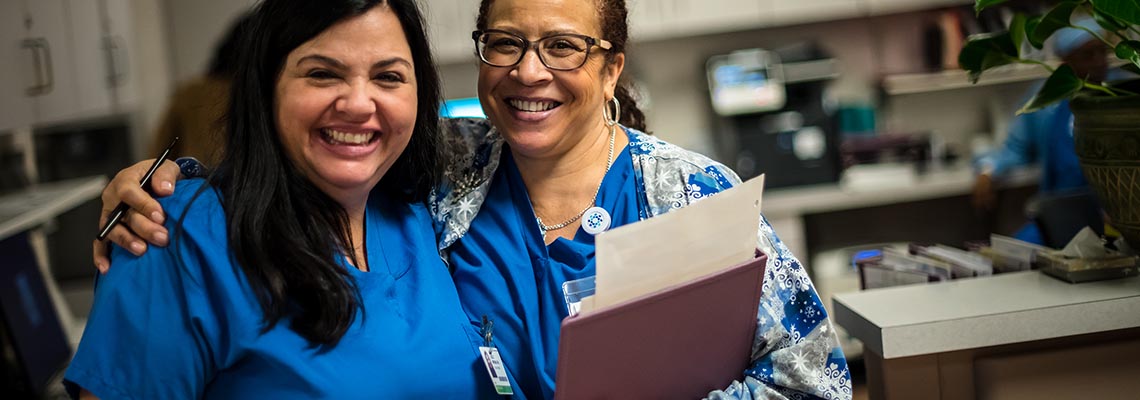 two female providers in the hospital smiling