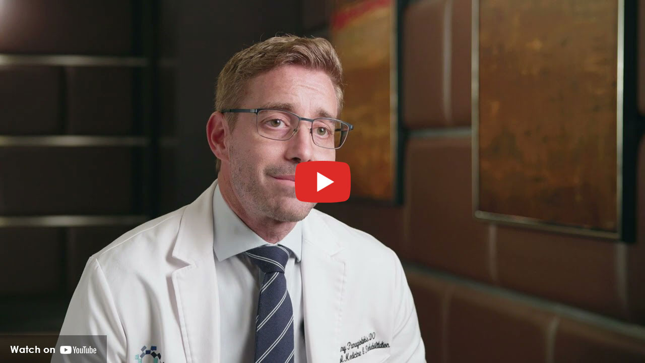 Doctor in a white coat speaking during an interview in a clinical setting