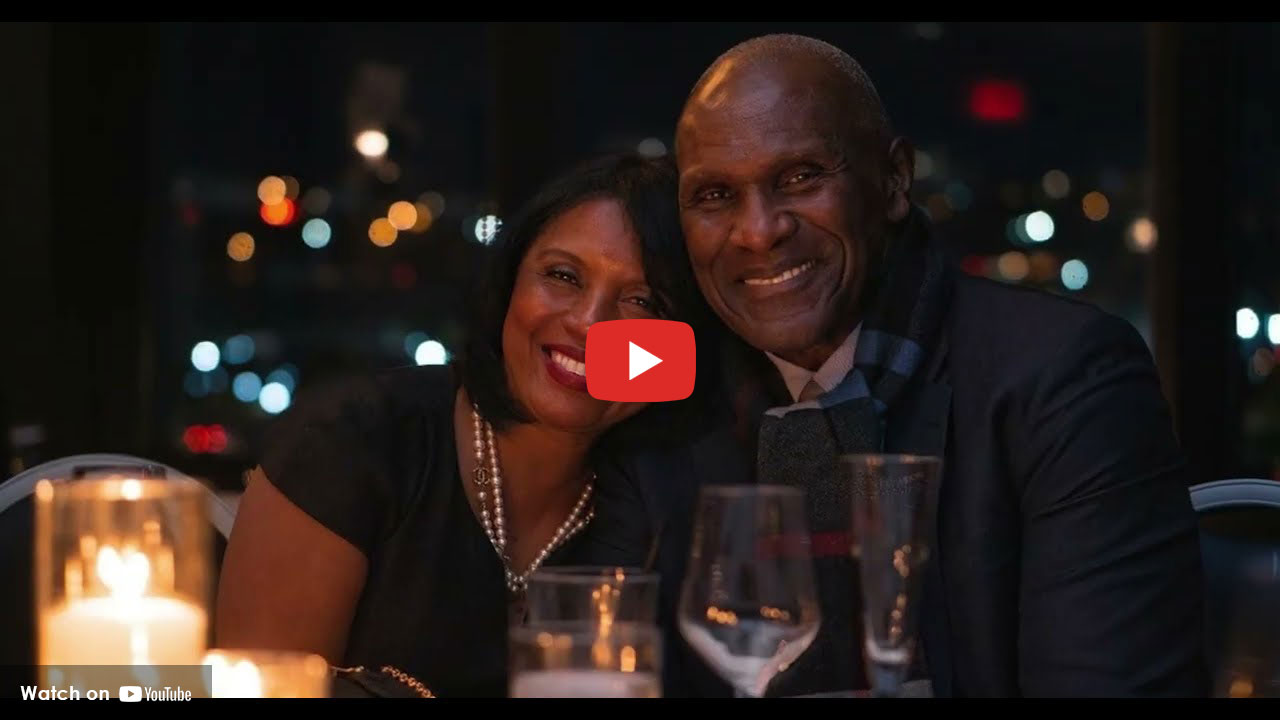 Couple smiling together while seated at a candlelit table in an evening setting