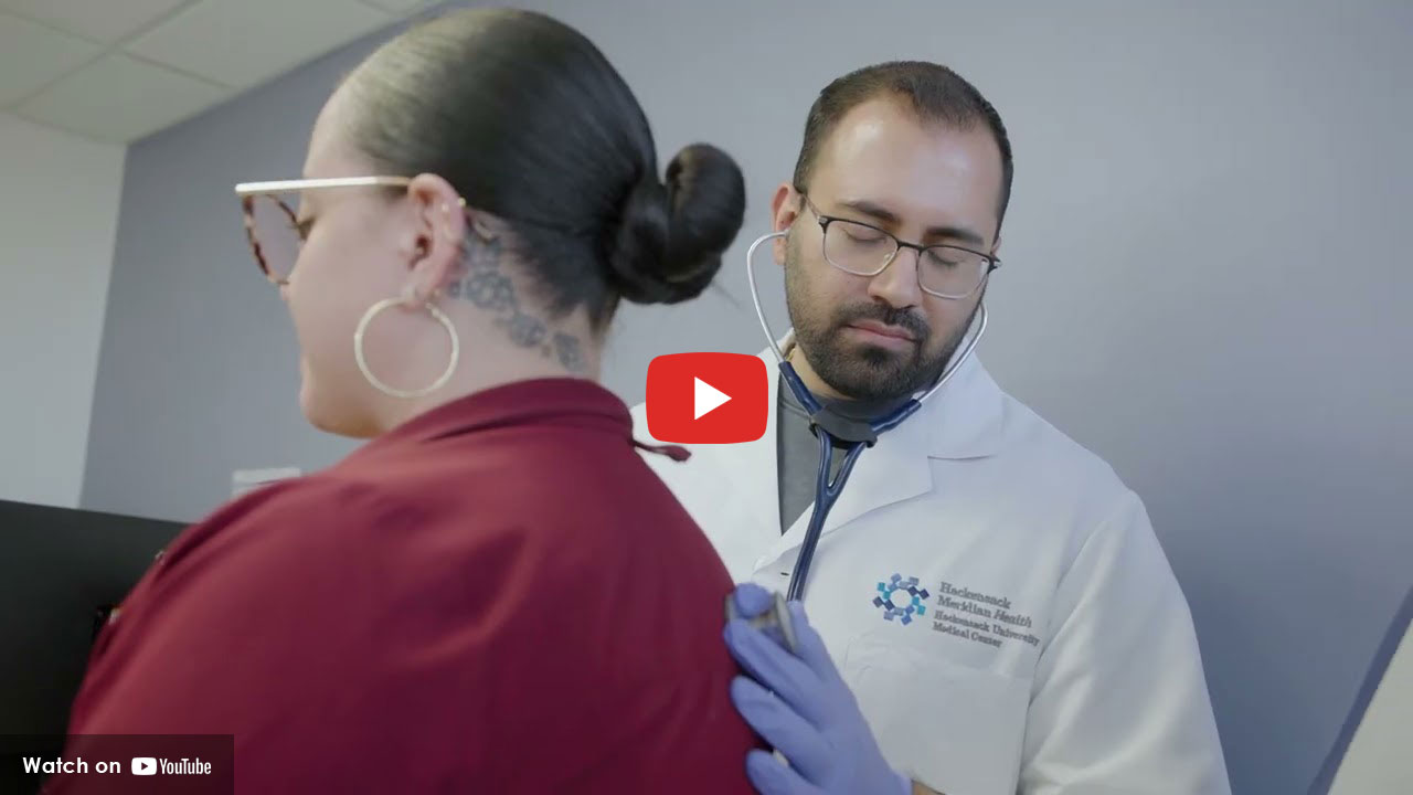 Physician listening to patient with stethoscope.