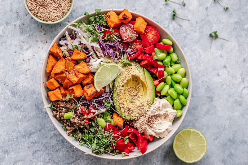 Overhead view of a colourful vegan bowl with quinoa, sweet potato ...