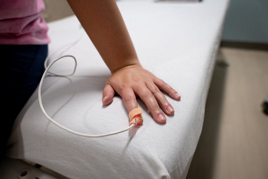 pediatric patient with a blood oxygen monitor on their finger