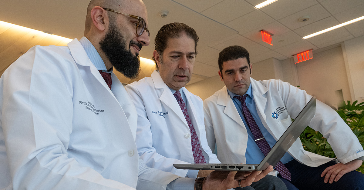 Three doctors review computer